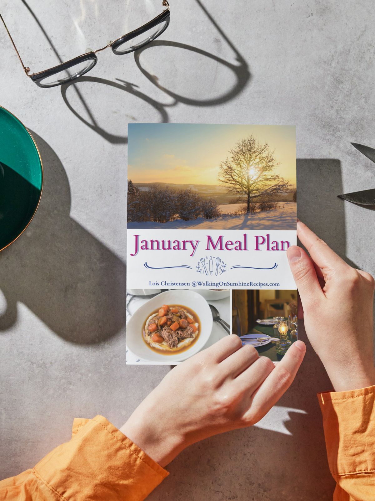 January Meal Plan printed out and held in hands.